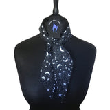 Lightweight cotton fabric scarf placed around a mannequins neck. Tied in a single loose knot around the neck with Nazine Alice Designs branded label. The fabric is an alternative gothic styled print of a black background with white pentagrams.