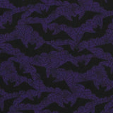 Close up of the fabric. A purple background with black spiderweb outlines and black bat silhouettes.