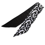 Lightweight cotton fabric scarf folded once to show front and back side. The front side fabric is an alternative gothic styled print of black background and white bats flying around, and the back side fabric is black. The edges are neatly hemmed.