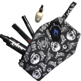 Coffin shaped makeup bag made with gothic fabric. The image shoes various makeup items inside, it can fit a lipstick, mascara, setting spray and highlighter. It has a coffin tag with the Nazine Alice Designs Logo on it.