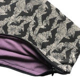 A close up of the bats coffin cosmetics bag which shows the zip and the lining inside the product which is a dark shade of purple. The zip is black, blends in, and is neatly hemmed.