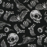 A close up of the fabric used for the gothic hair scrunchies. It is a plain black background and the pattern on top is white. The pattern includes skulls, skeletons, eyeballs, spiders, crows and bats.